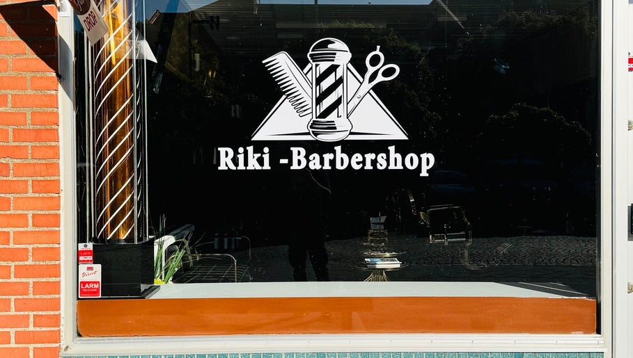 Riki-Barbershop fönsterskylt i Ängelholm, Skåne Län, SE med klassiska barberarsymboler.