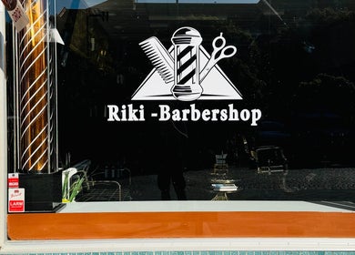 Riki-Barbershop fönsterskylt i Ängelholm, Skåne Län, SE med klassiska barberarsymboler.