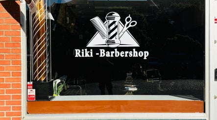Riki-Barbershop fönsterskylt i Ängelholm, Skåne Län, SE med klassiska barberarsymboler.