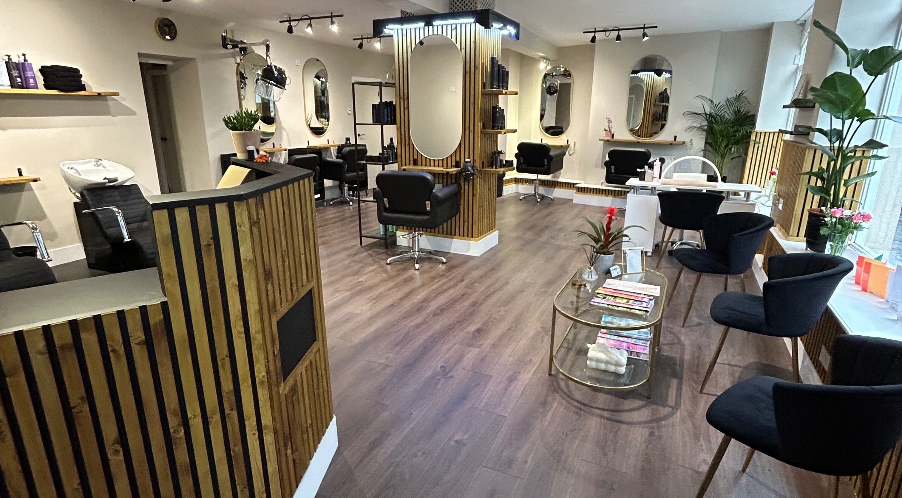 Interior of Elegance Hair and Beauty in Teignmouth, England, GB, showcasing stylish seating and mirrors.