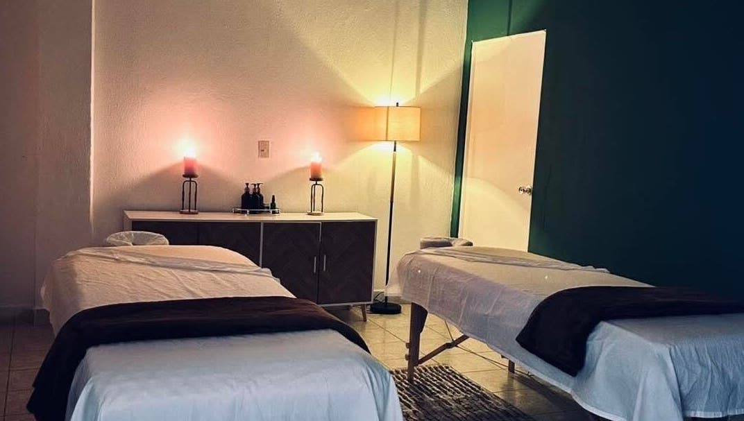Sala de masajes en Serenity Spa, Loreto, Baja California Sur, MX, con camas dobles, velas y lámpara.