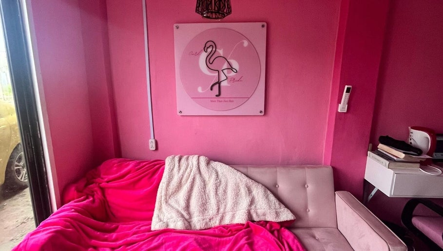 Cozy pink lounge at Curl Pride gy, West Bank Demerara, GY with flamingo decor and plush seating.