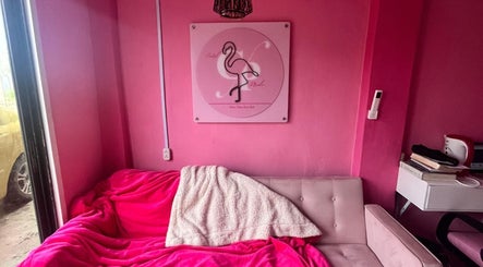 Cozy pink lounge at Curl Pride gy, West Bank Demerara, GY with flamingo decor and plush seating.