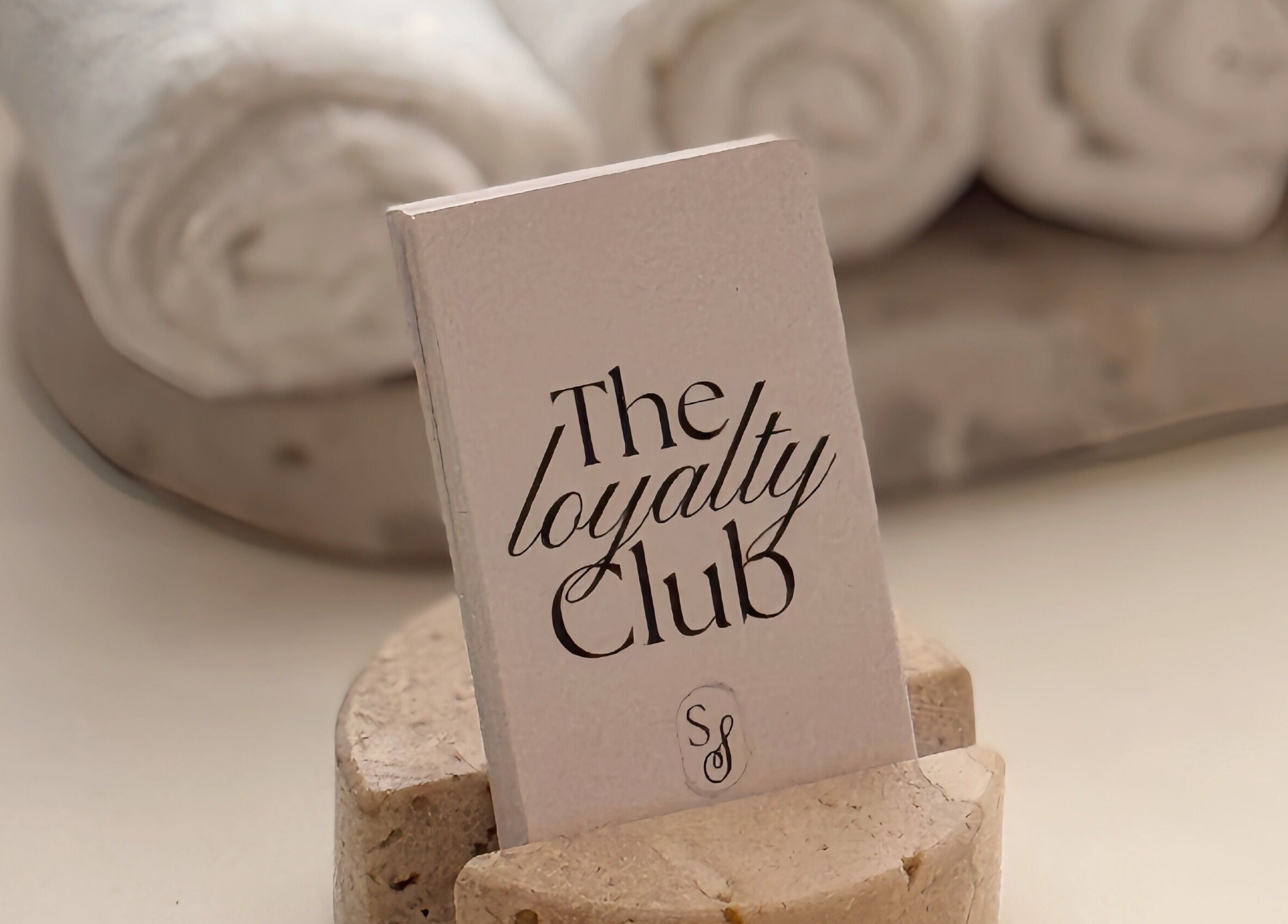 Studio Silk's Loyalty Club card displayed with rolled towels in Melbourne, Victoria, AU.