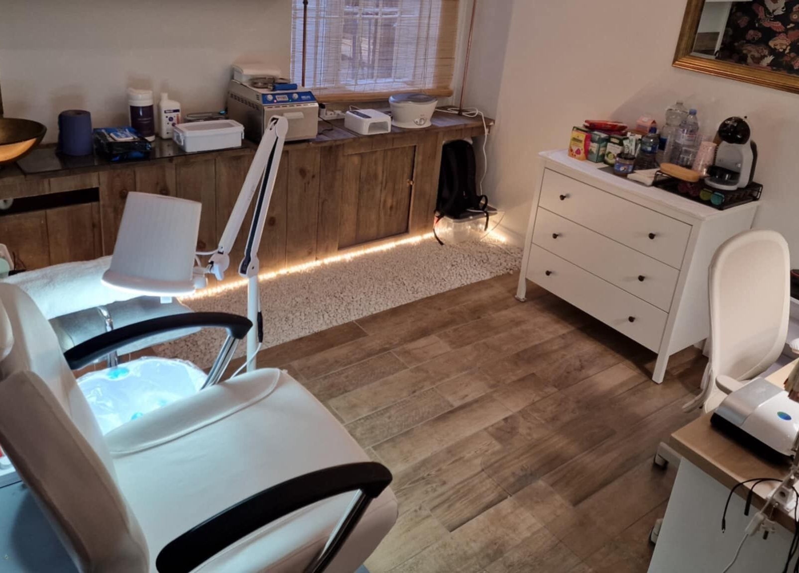 Cozy nail treatment room at Chique Nail Studio in London, England, GB, featuring modern equipment and wooden decor.