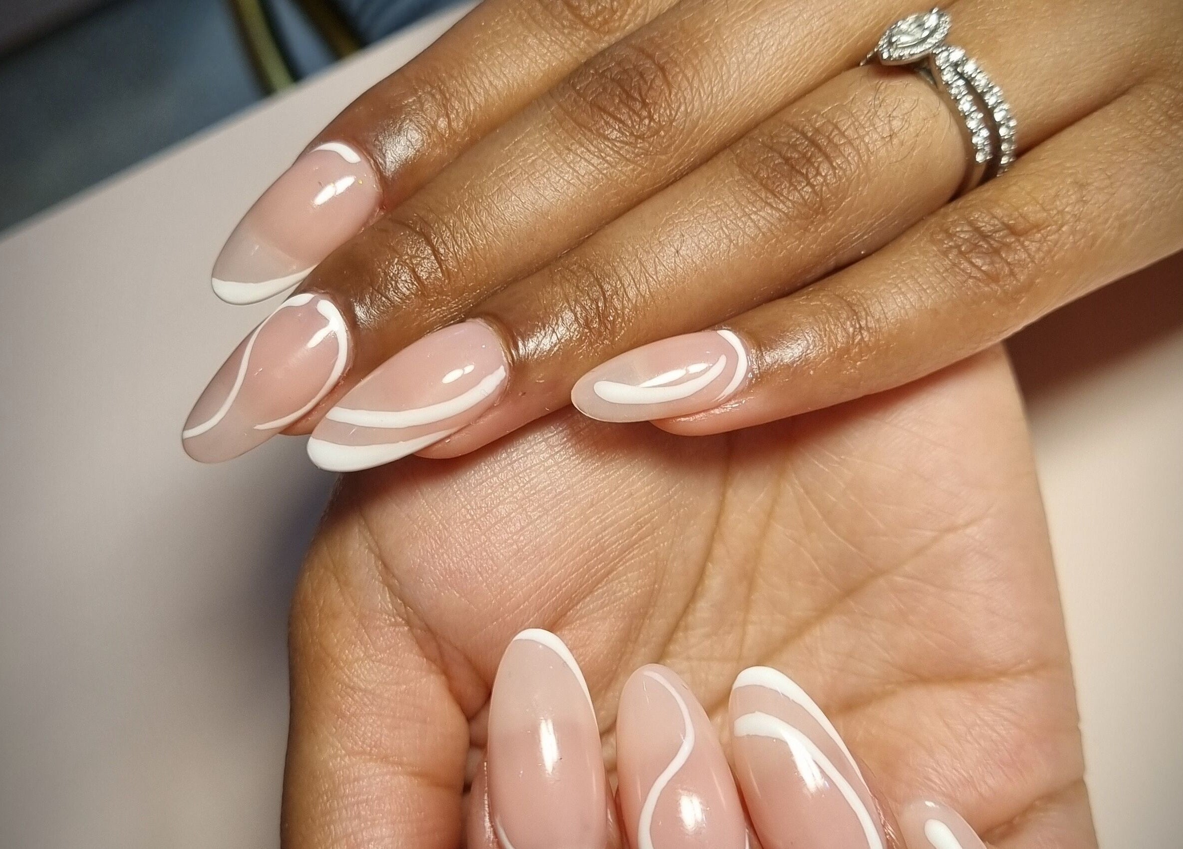 Stylish swirl nail art at Chique Nail Studio, London, England, GB. Perfectly manicured hands with elegant designs.