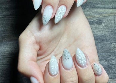 Elegant winter-themed nail art at Ninnie's in Boksburg, Gauteng, ZA. Features snowflakes and silver glitter.