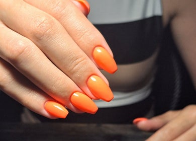 Bright orange nails showcased at Ninnie's, Boksburg, Gauteng, ZA, highlighting expert manicure service.