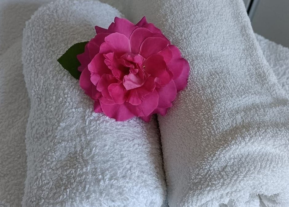 Serviettes blanches avec une fleur rose au Sublim'Ton Corps, Aigrefeuille-d'aunis, Nouvelle-aquitaine, FR.