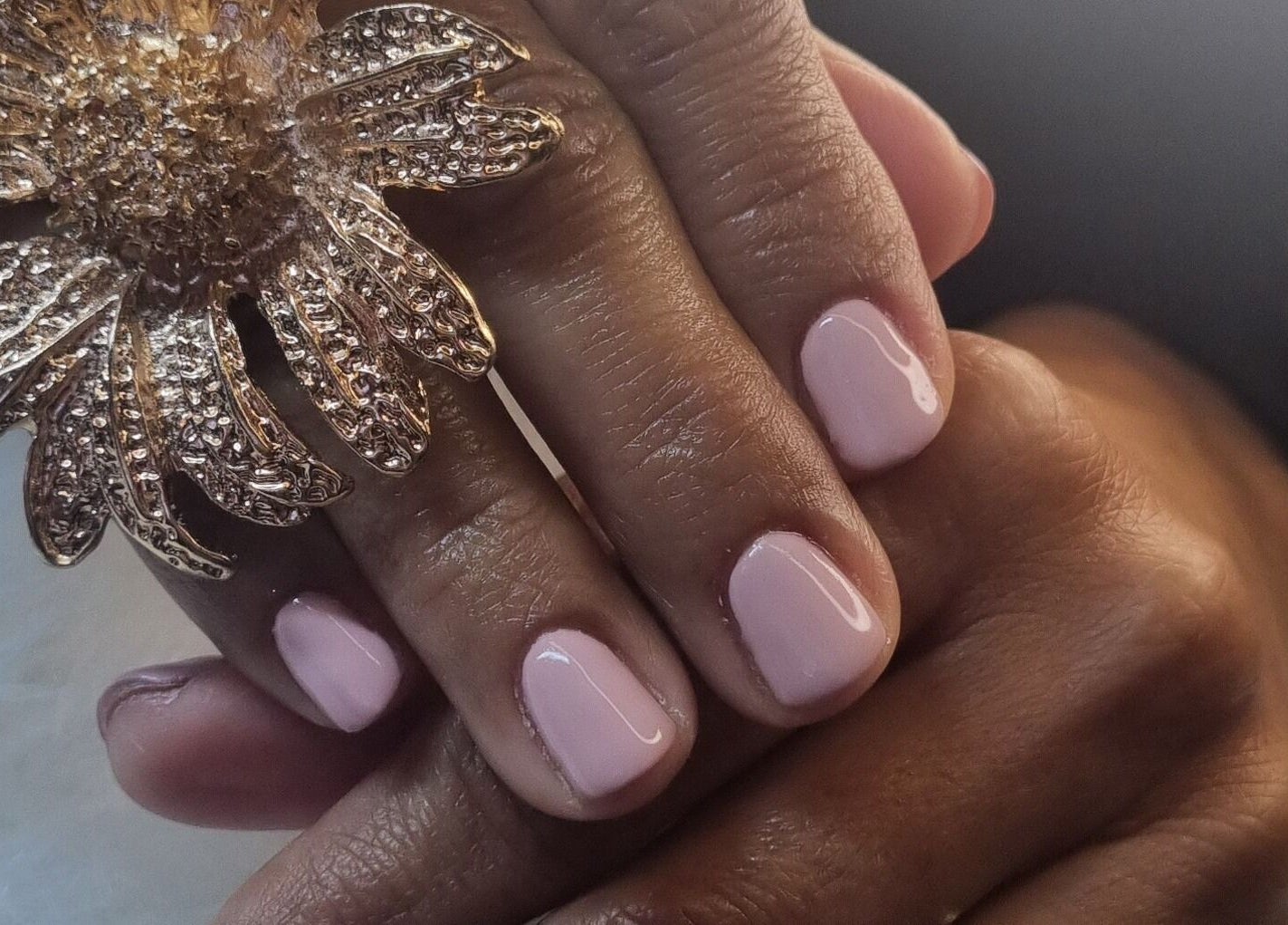 Nail art delicata a Girasole Beauty & Nails, Cappelle Sul Tavo, Abruzzo, IT con anello floreale dorato.