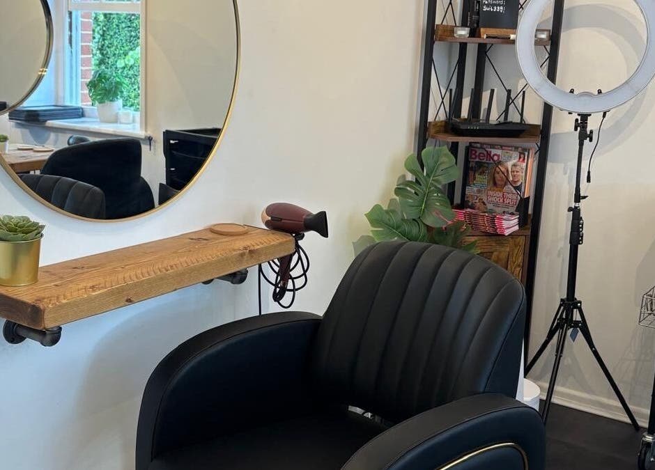 Modern salon setup at Hair By Milly Rose in Basingstoke, England, GB with sleek chair and round mirror.