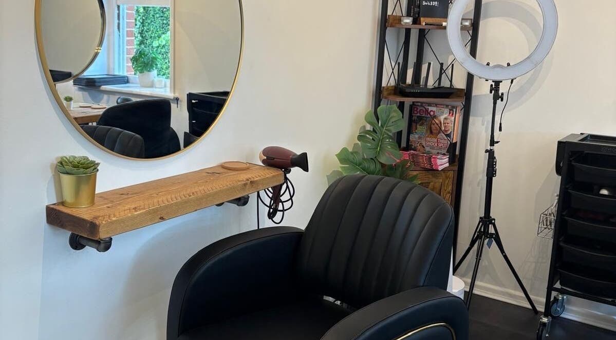 Modern salon setup at Hair By Milly Rose in Basingstoke, England, GB with sleek chair and round mirror.