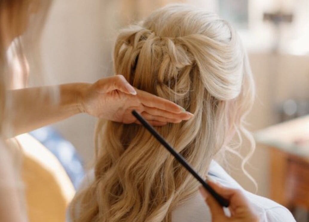 A stylist braiding hair at Hair By Milly Rose in Basingstoke, England, GB, creating an elegant look.