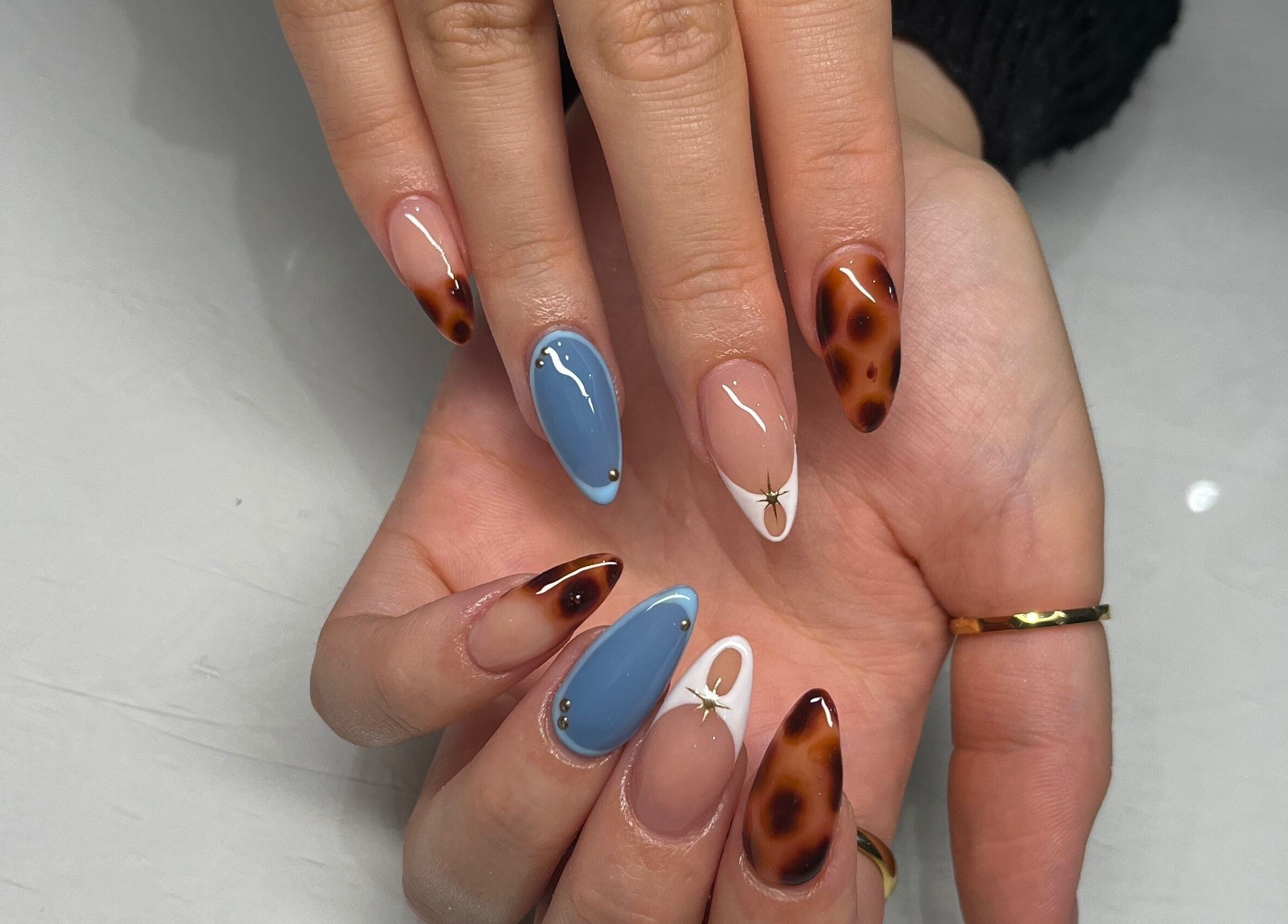 Stylish nail art with blue and tortoiseshell design at By Amelia, Thurmaston, England, GB.