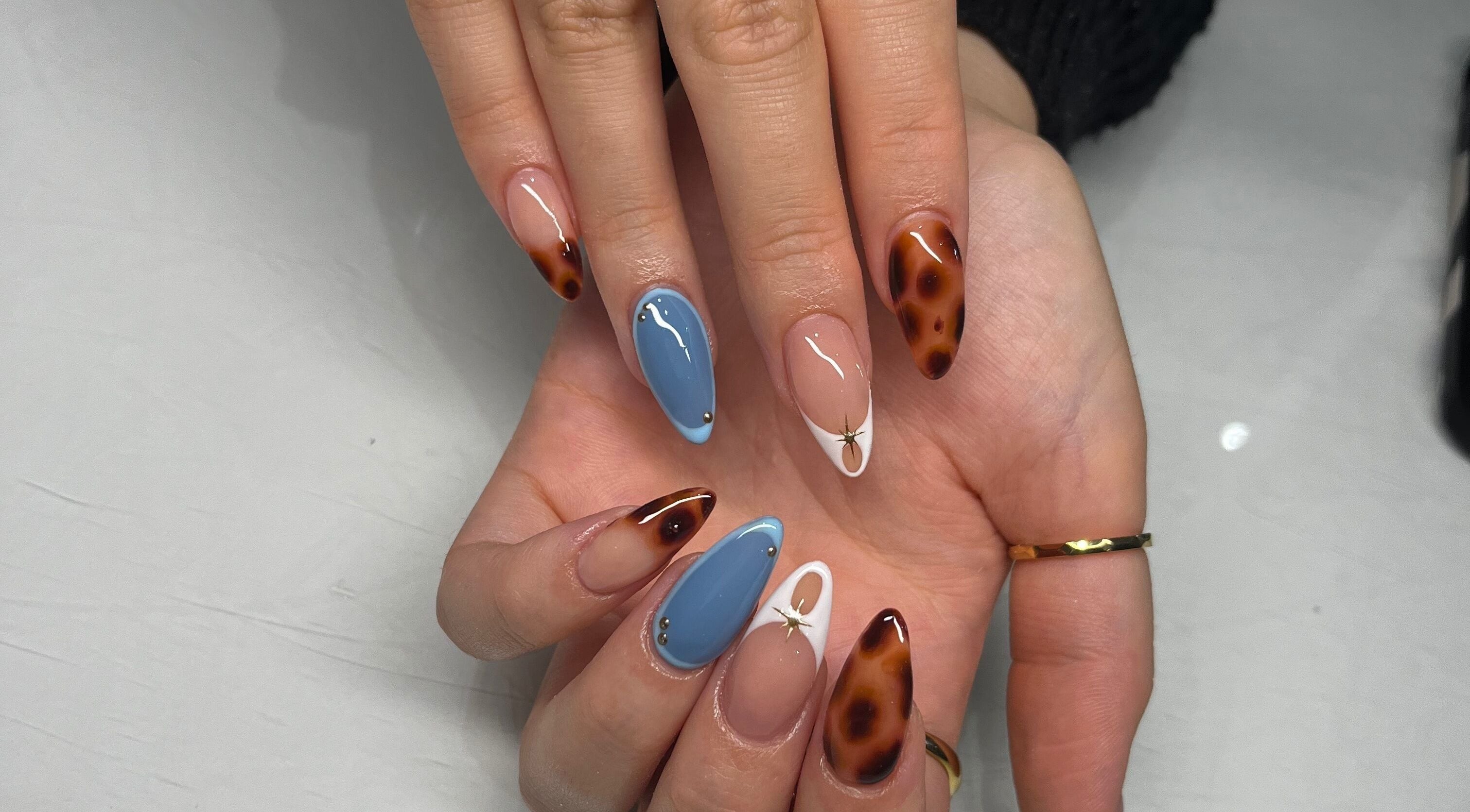 Stylish nail art with blue and tortoiseshell design at By Amelia, Thurmaston, England, GB.