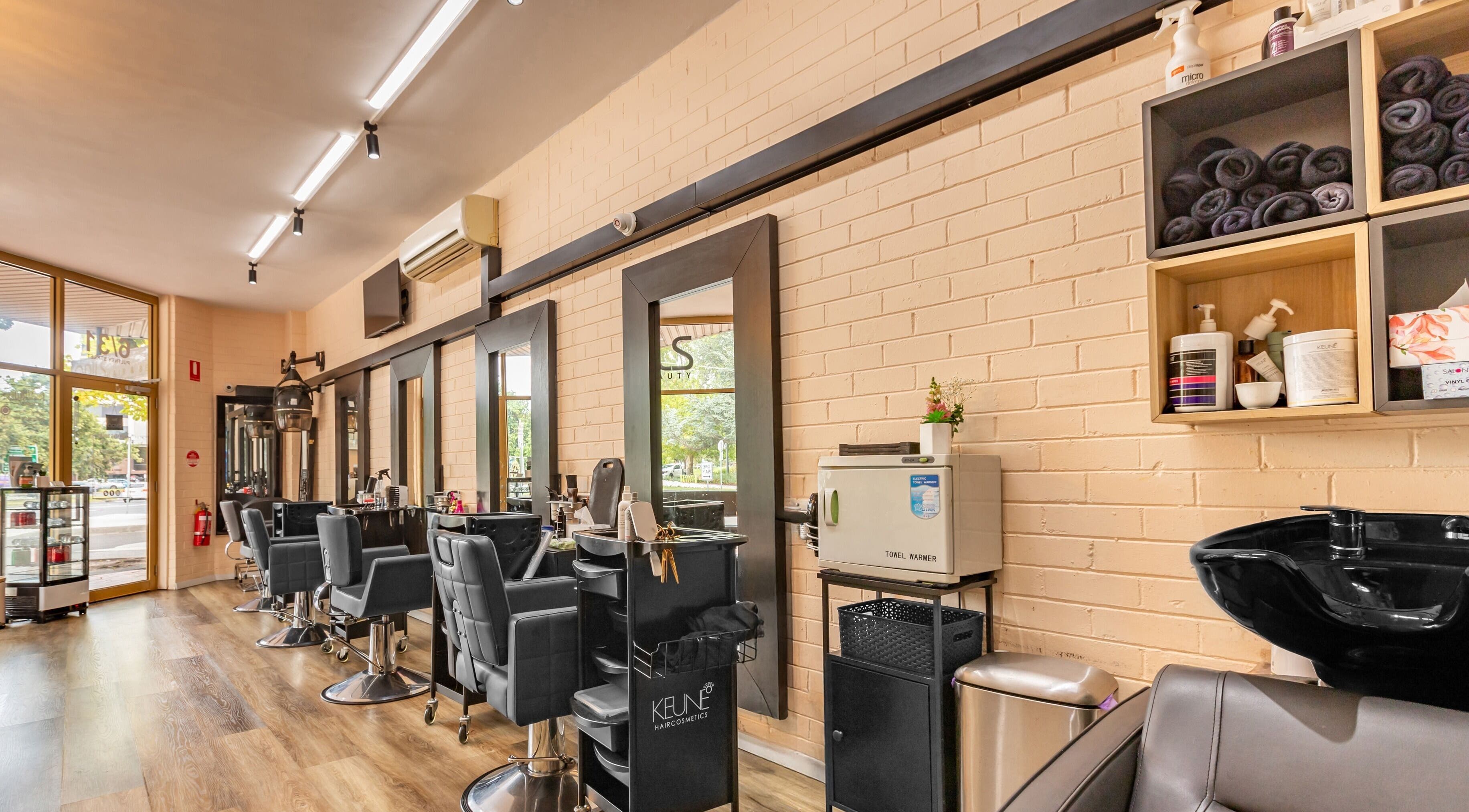 Modern salon interior at Odils Hair & Beauty, Melbourne, Victoria, AU with stylish chairs and mirrors.