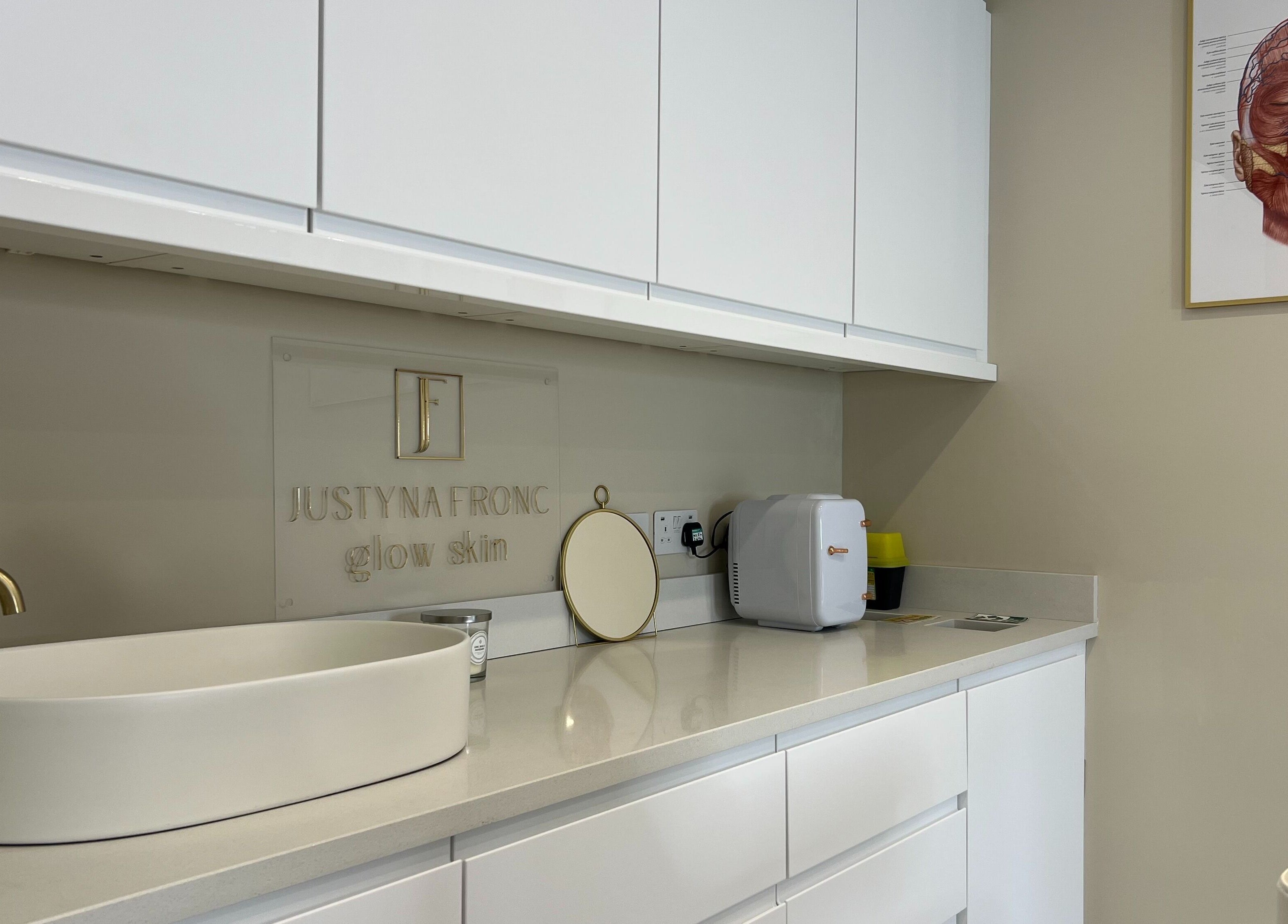 Modern counter at Glow Skin Justyna Fronc, London, England, GB, featuring a sleek white sink and gold faucet.