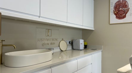 Modern counter at Glow Skin Justyna Fronc, London, England, GB, featuring a sleek white sink and gold faucet.