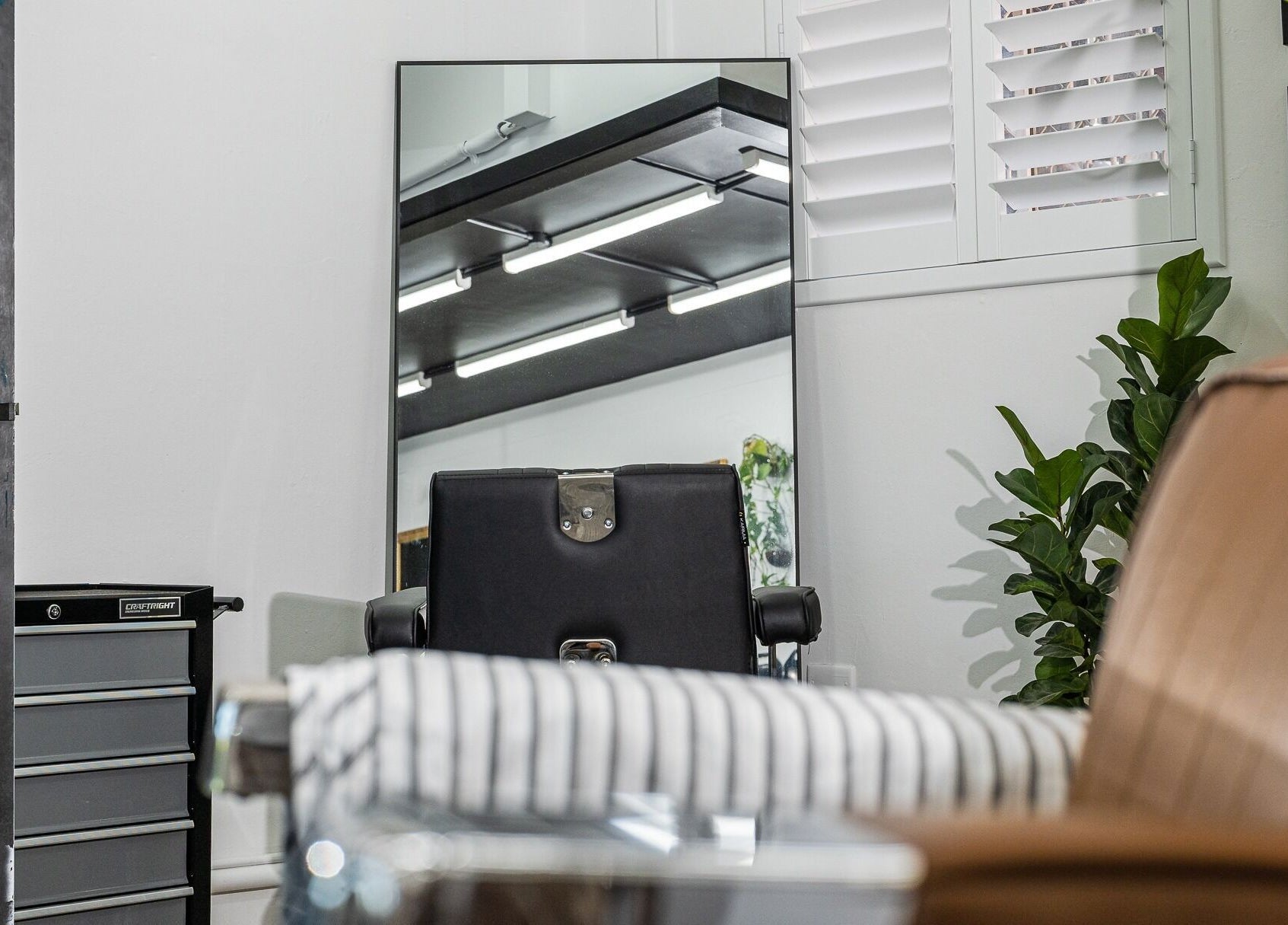 Modern barber chair reflecting in a mirror at Broken Hearts Barbershop, Port Macquarie, New South Wales, AU.