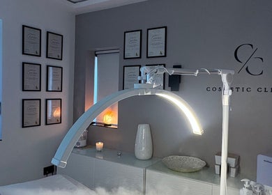 Modern treatment room at Cosmetic Clinic, Calverley, England. Elegant setup with certificates and soft lighting.