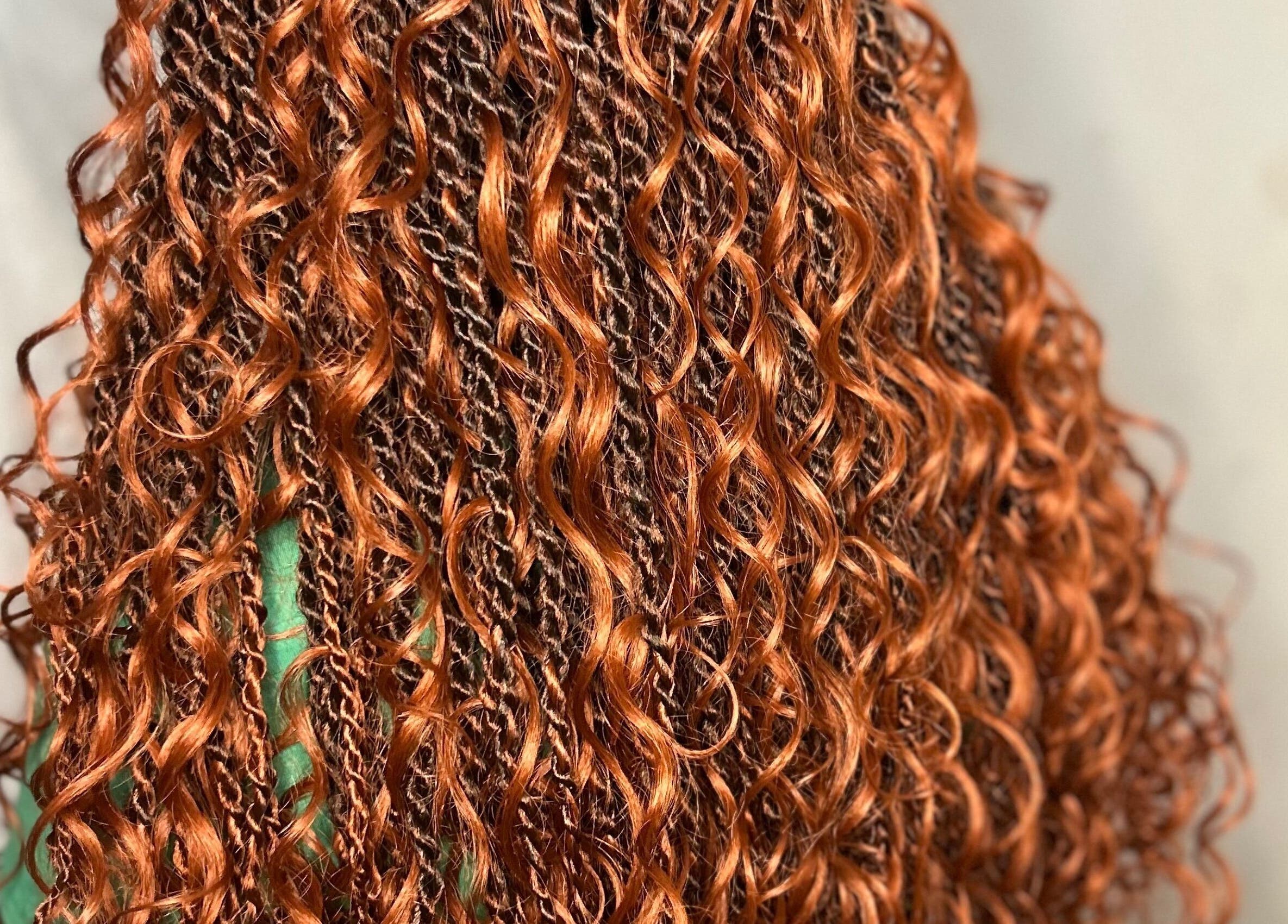 Vibrant copper curls styled at Styled by Tammy in Marigot, MF, showcasing intricate braiding work.