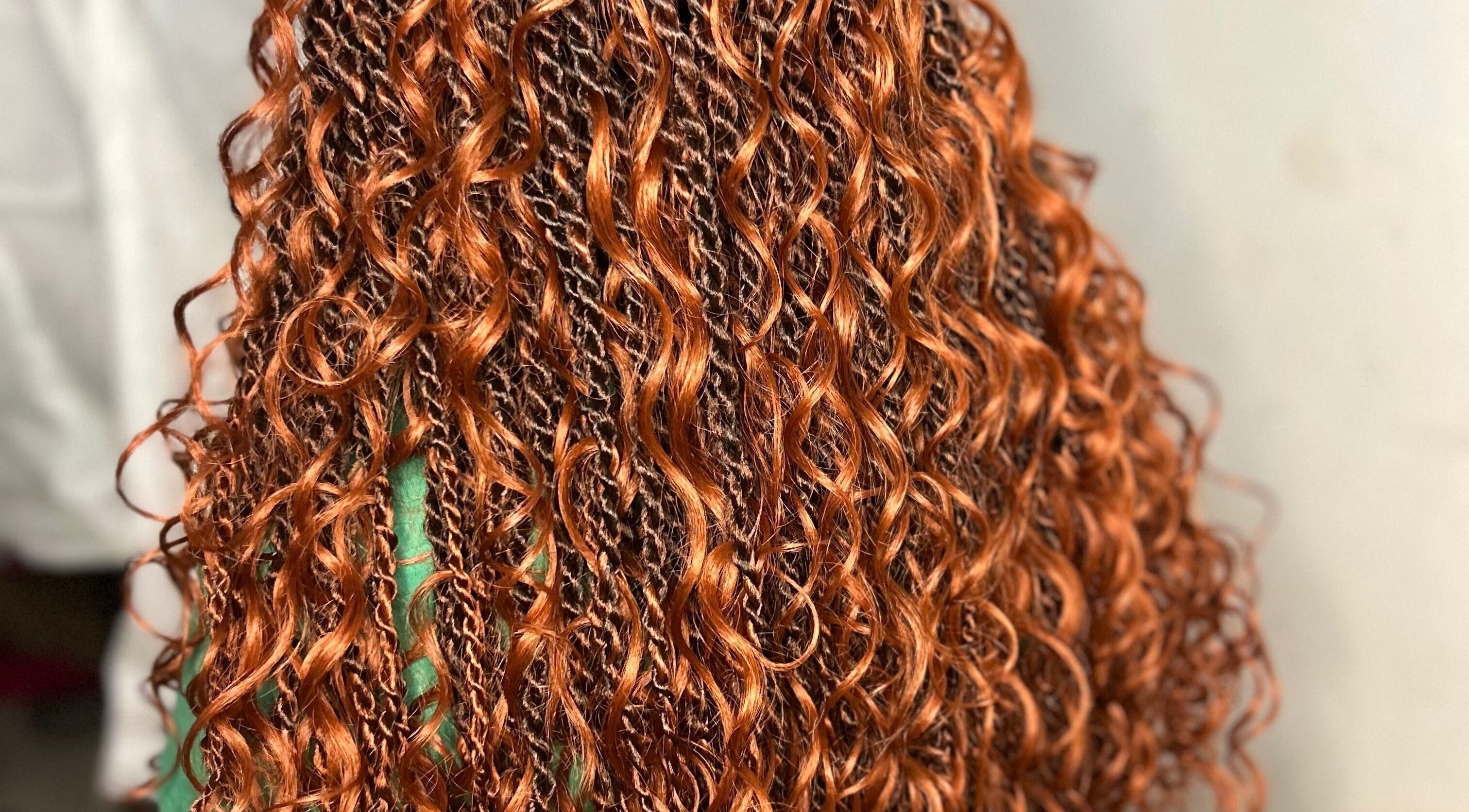 Vibrant copper curls styled at Styled by Tammy in Marigot, MF, showcasing intricate braiding work.