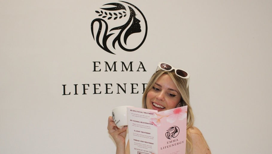 Woman reading brochure at Emma Lifeenergy, Beckenham, England, GB, showcasing their beauty treatments.