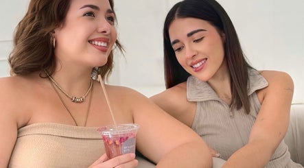 Dos mujeres sonriendo y disfrutando de una bebida en Aguinay, Ciudad Lázaro Cárdenas, Michoacán, MX.