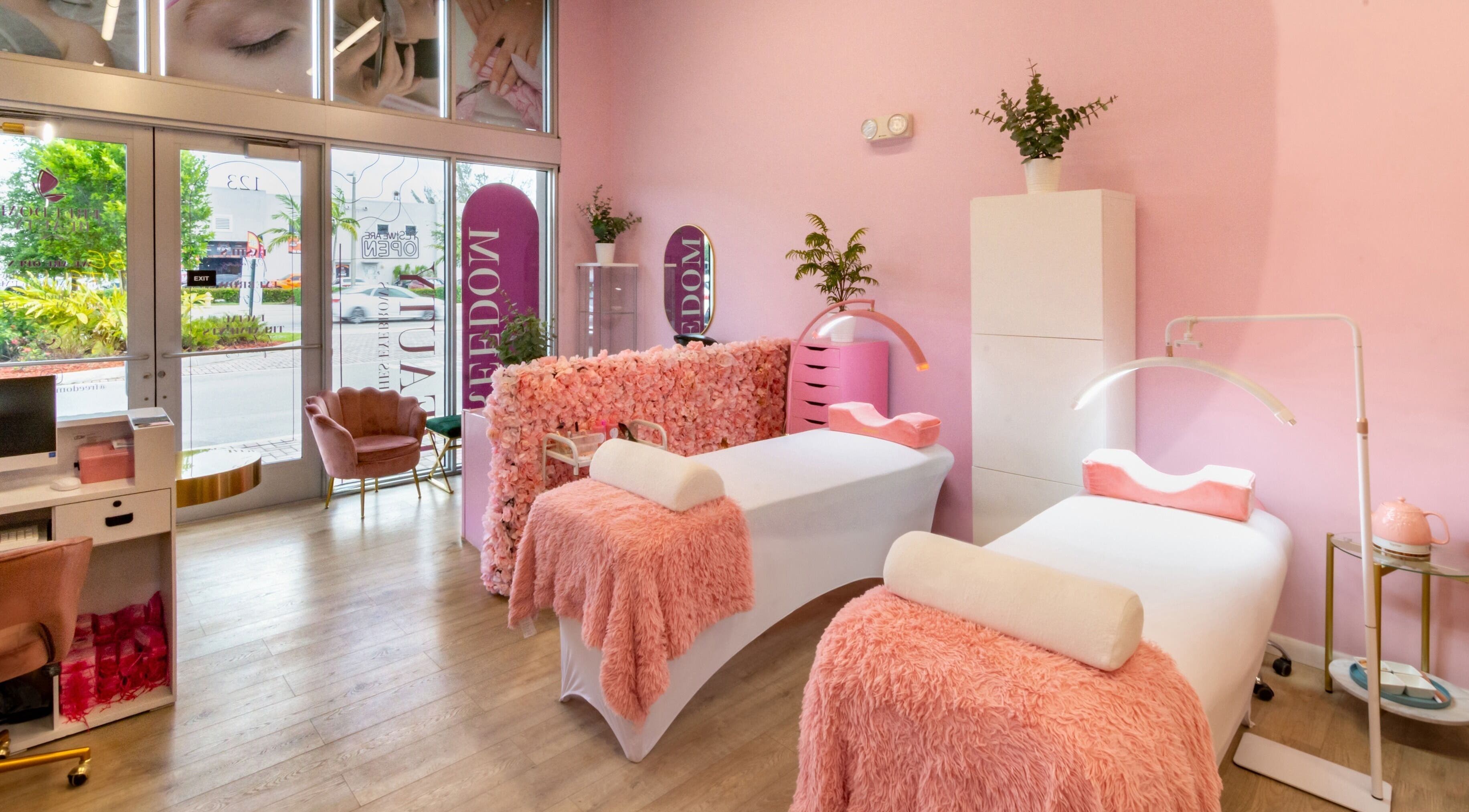 Spa room at Freedom Beauty, Miami, Florida, US with two pink treatment beds and lush decor for ultimate relaxation.
