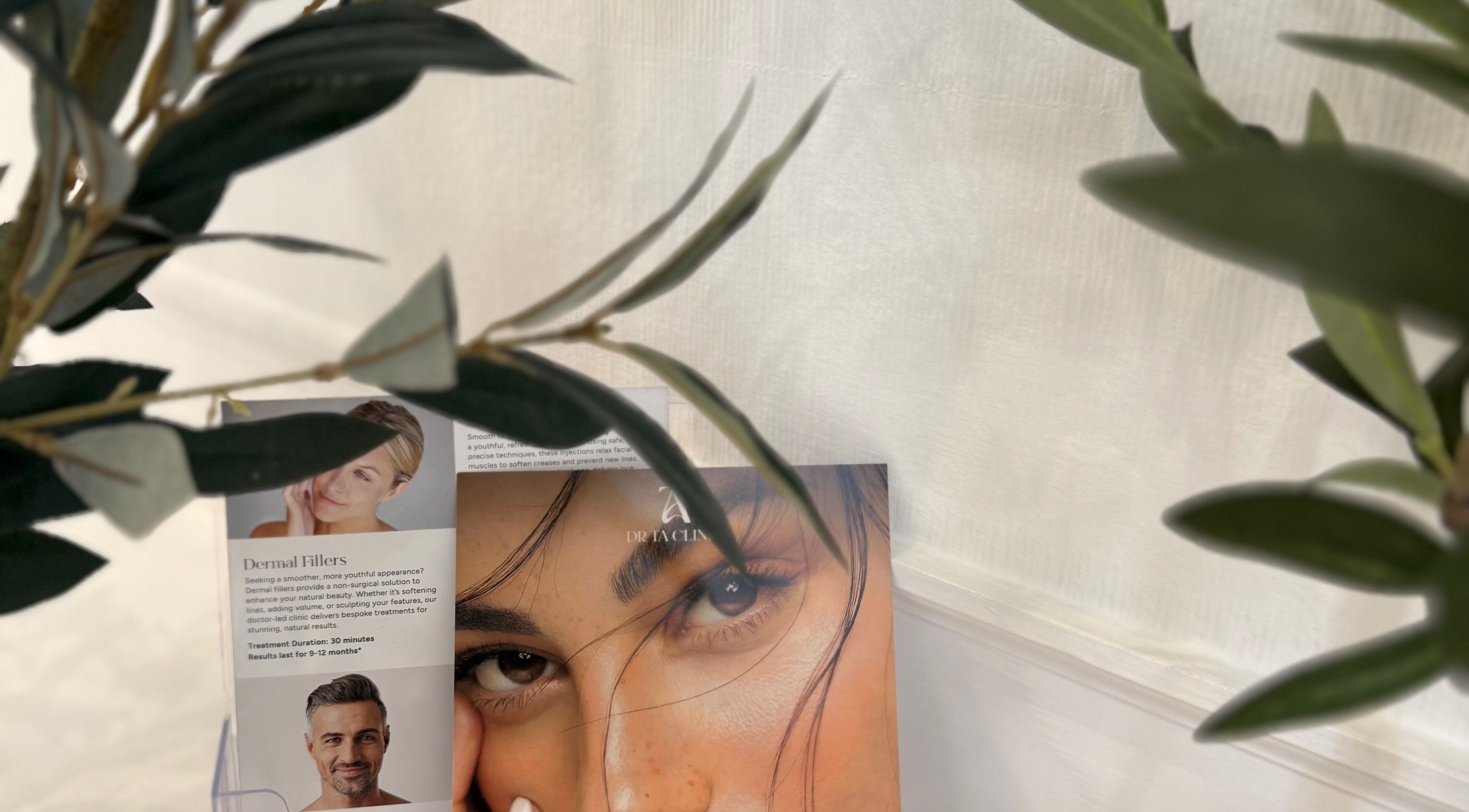 Promotional banner for dermal fillers at DrTA Clinic, Bathpool, England, GB, adorned with natural greenery.