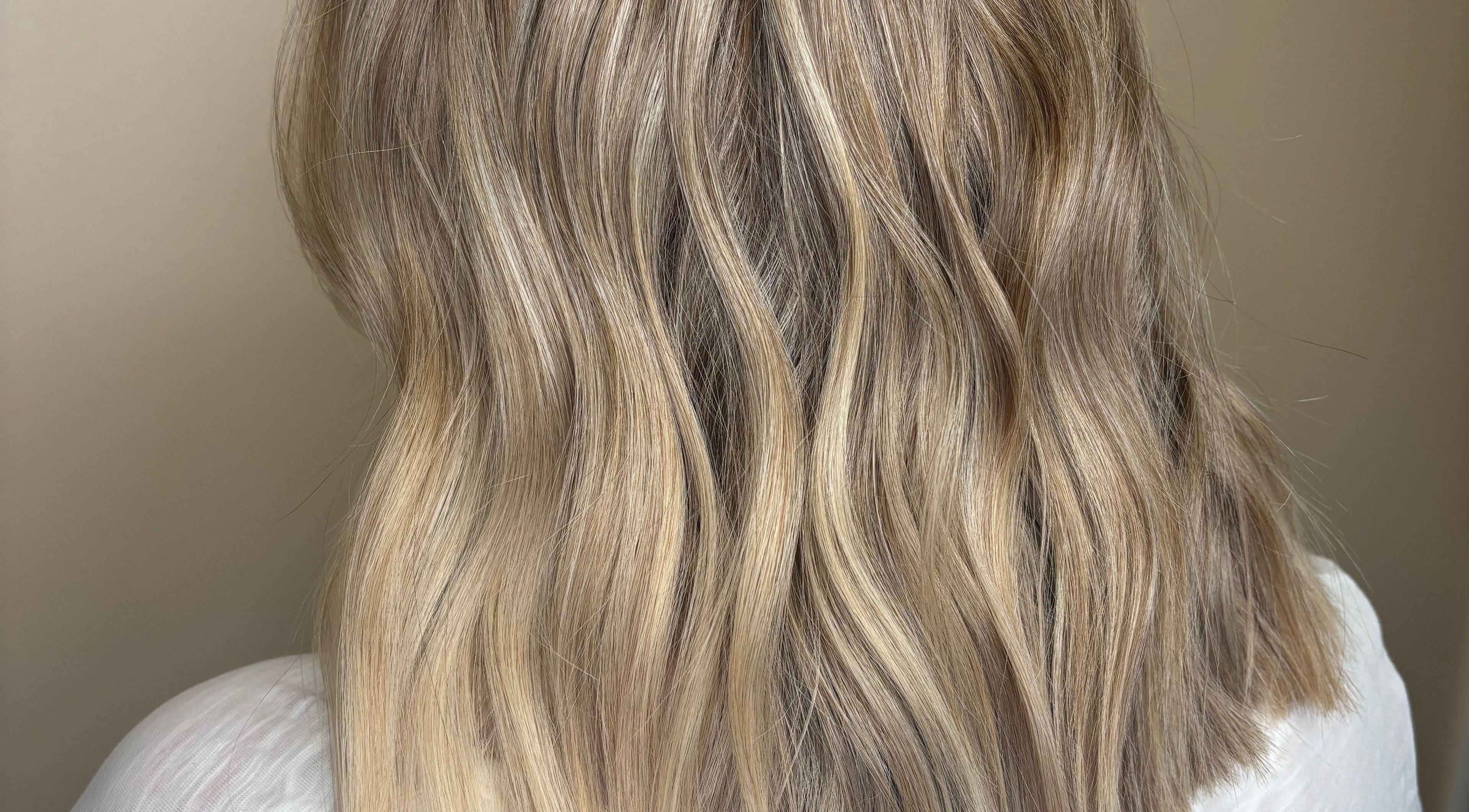 Soft blonde waves styled at Hannah Cox Hair, Reading, England, GB depict elegance and expertise.