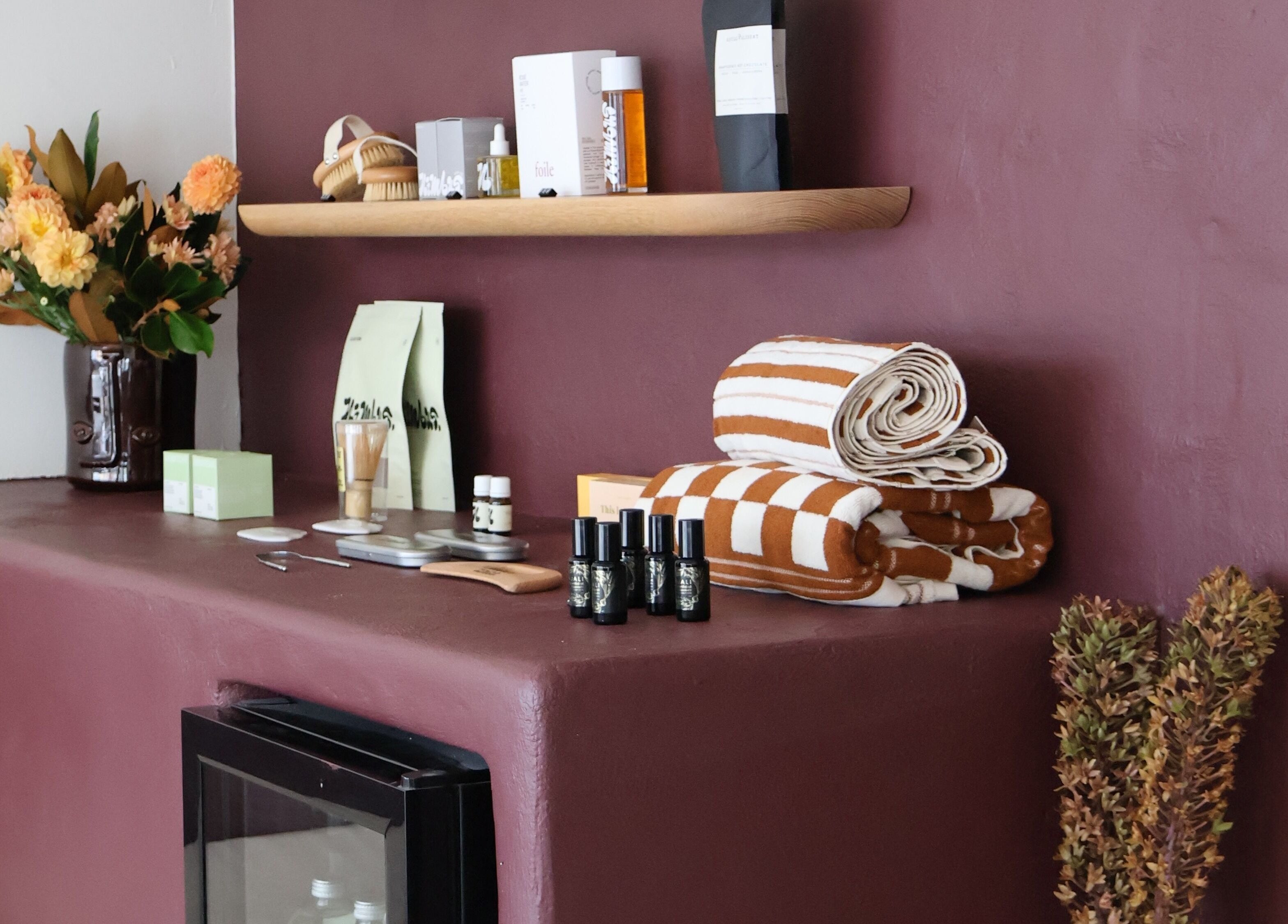 Nimbus Co Queenscliff displays wellness essentials in Manly, New South Wales, AU with towels and skincare items.