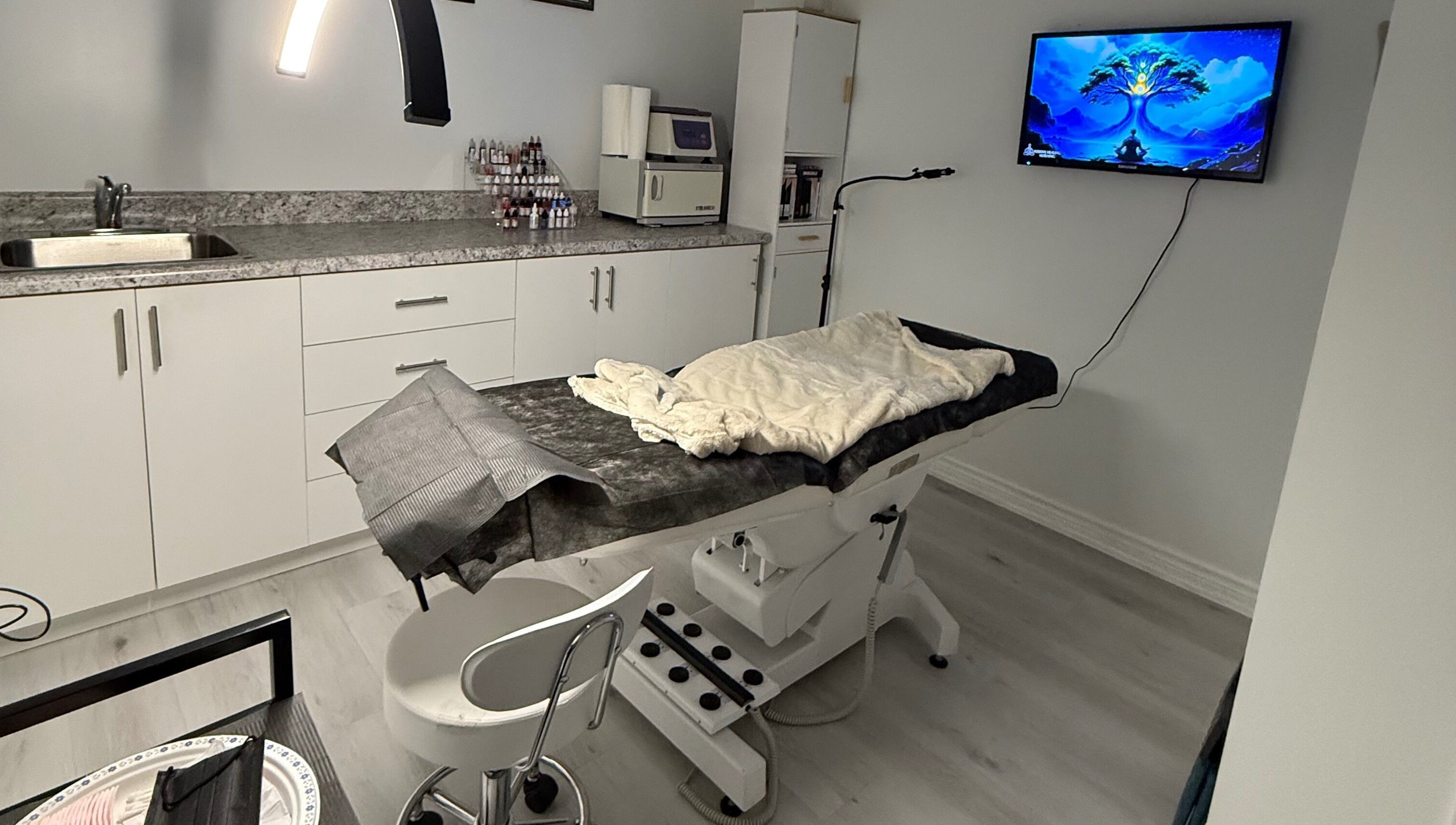 Modern treatment room at Miss Kris PMU, Toronto, Ontario, CA. Features chair, counter, and soft lighting.