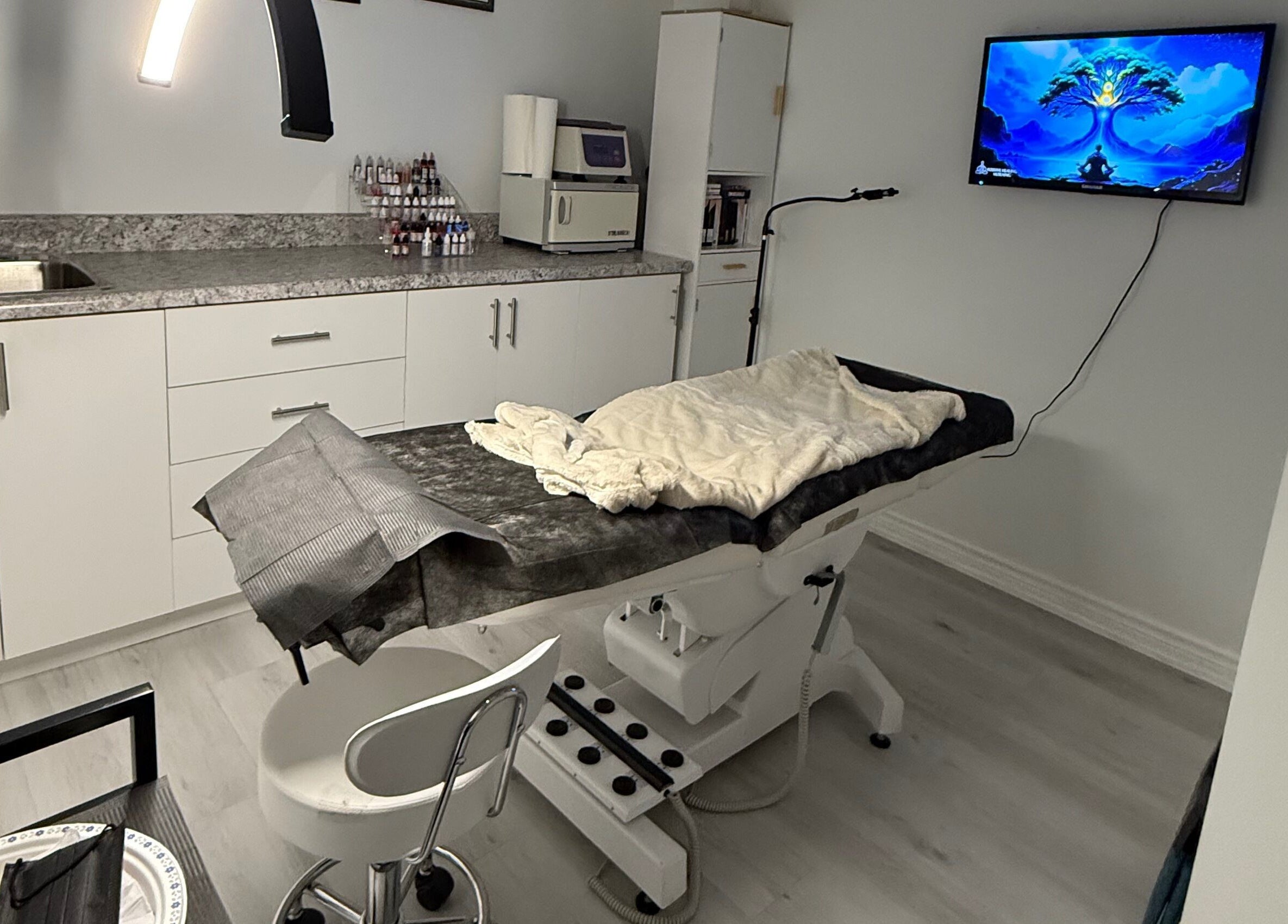 Modern treatment room at Miss Kris PMU, Toronto, Ontario, CA. Features chair, counter, and soft lighting.