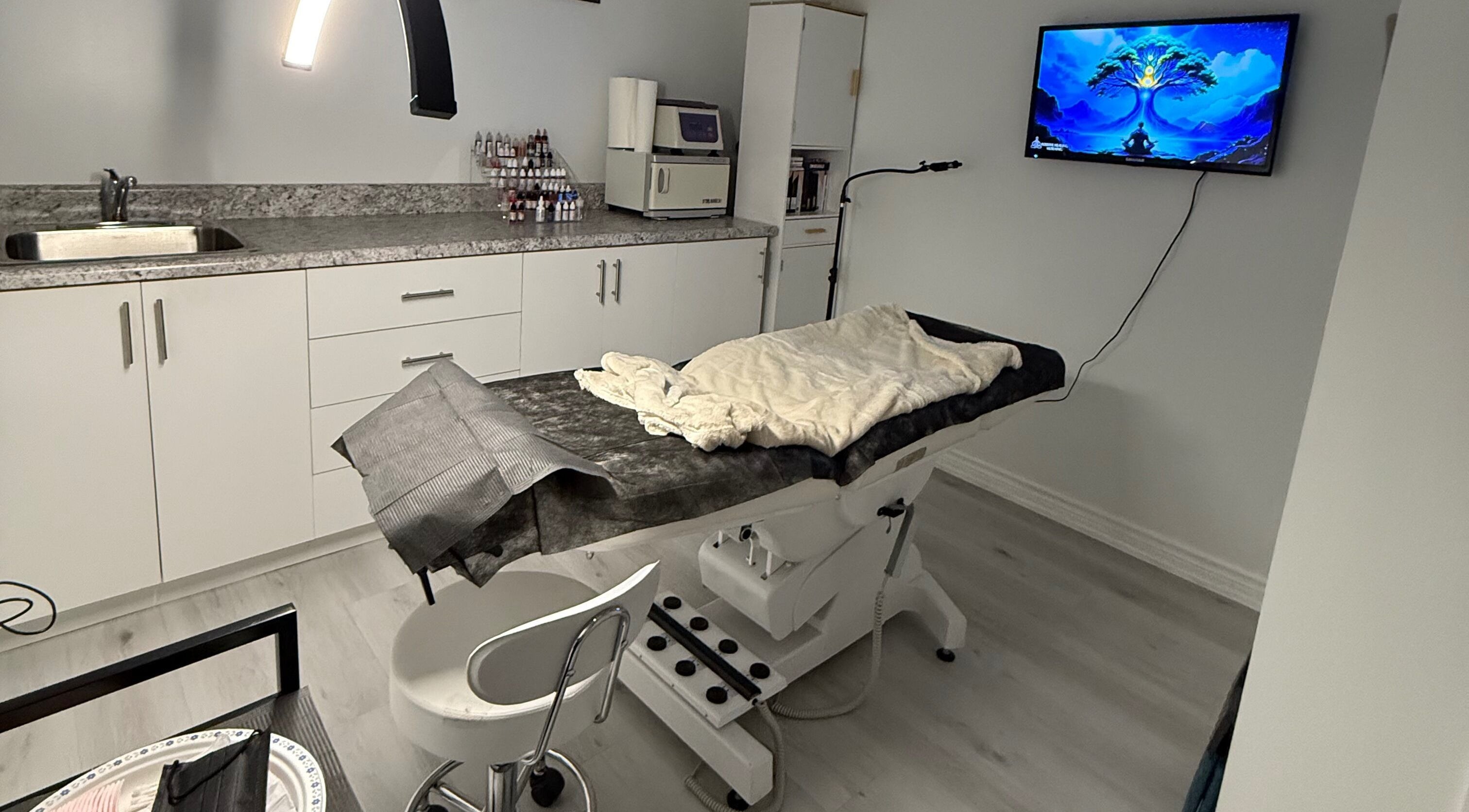 Modern treatment room at Miss Kris PMU, Toronto, Ontario, CA. Features chair, counter, and soft lighting.
