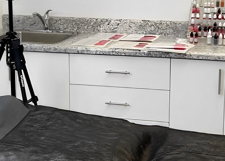 Professional PMU workspace at Miss Kris PMU, Toronto, Ontario, CA with ink bottles and tools organized.