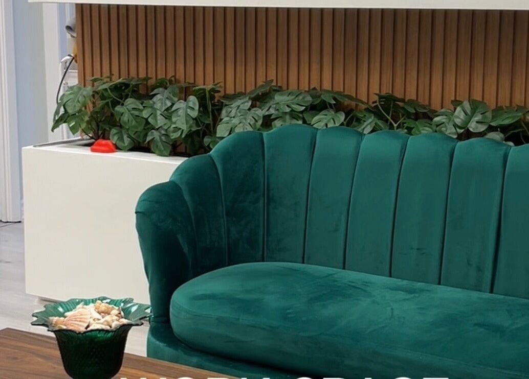 Elegant green sofa and plants at Miss Kris PMU in Toronto, Ontario, CA showcasing a serene and inviting space.