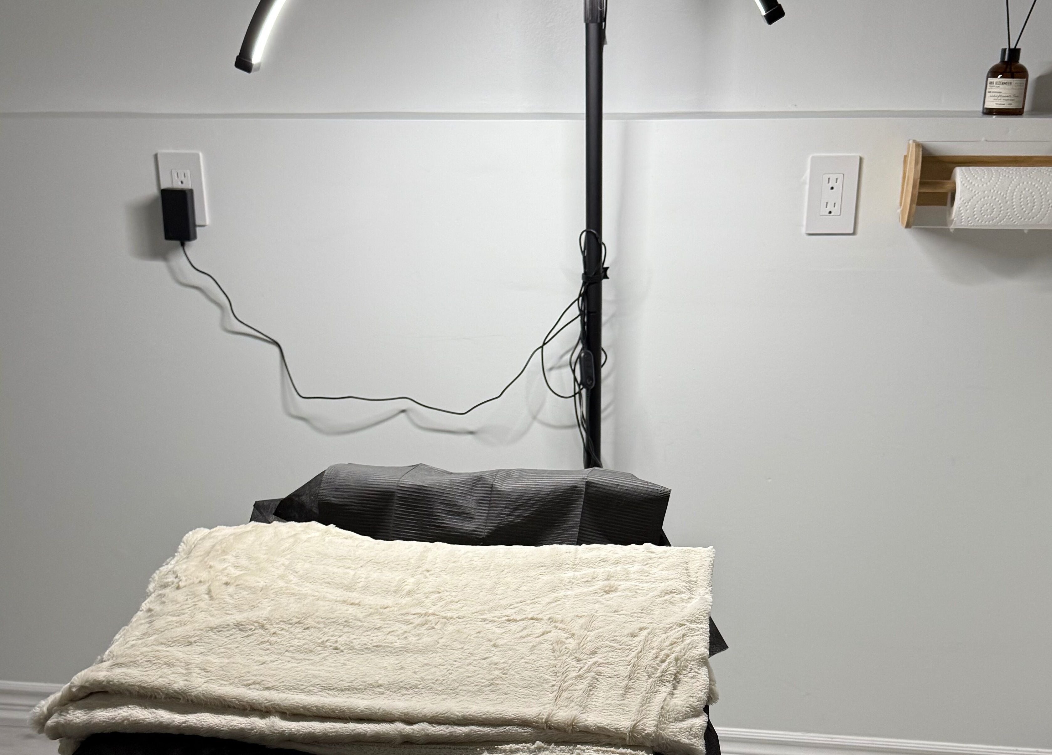 Cosy treatment area at Miss Kris PMU in Toronto, Ontario, CA, featuring a plush table and soft lighting.