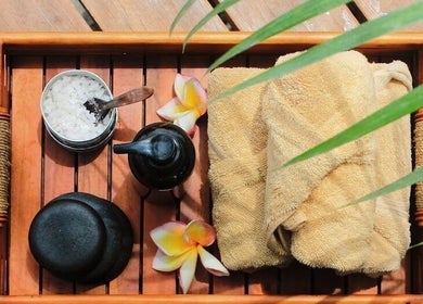 Relaxing spa essentials at ZIN SPA Canggu, Bali, Bali, ID - a wooden tray with towels and oils.