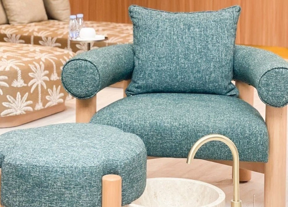 Luxurious seating at Vaya Salon, Riyadh, SA, featuring plush teal upholstery and serene decor.