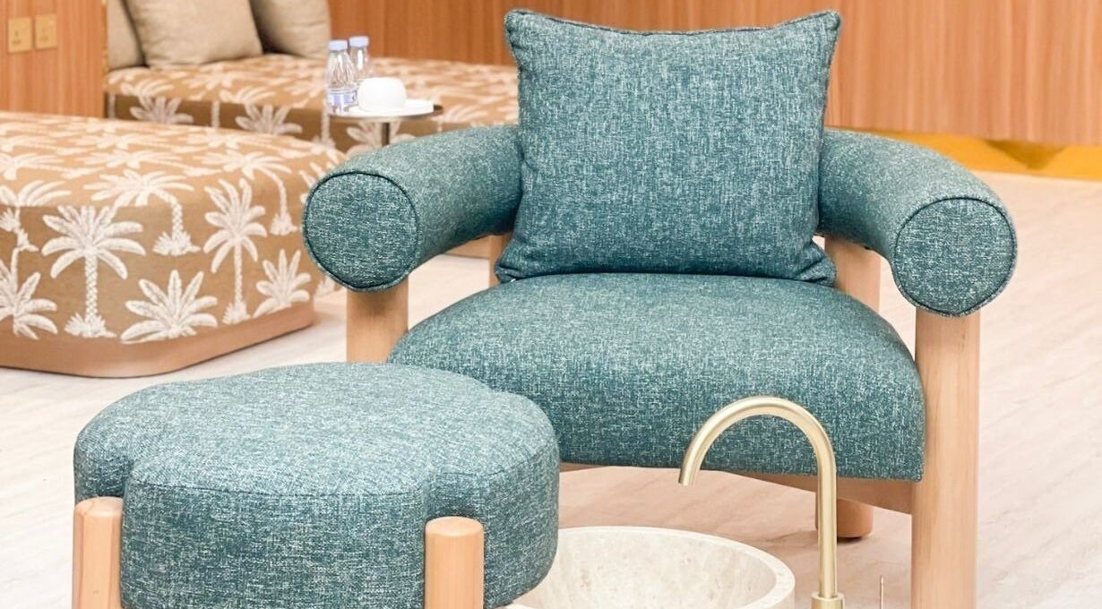 Luxurious seating at Vaya Salon, Riyadh, SA, featuring plush teal upholstery and serene decor.