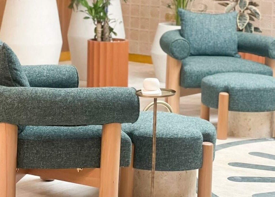 Relax in Vaya Salon's chic seating area in Riyadh, SA, featuring stylish teal chairs and modern decor.