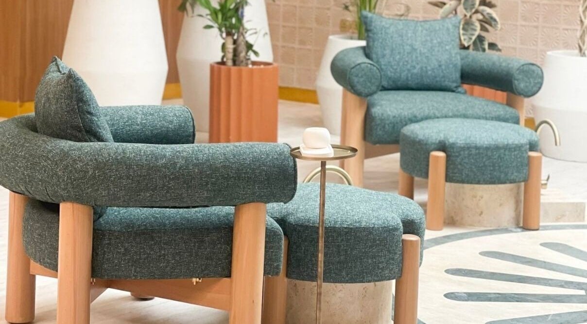 Relax in Vaya Salon's chic seating area in Riyadh, SA, featuring stylish teal chairs and modern decor.