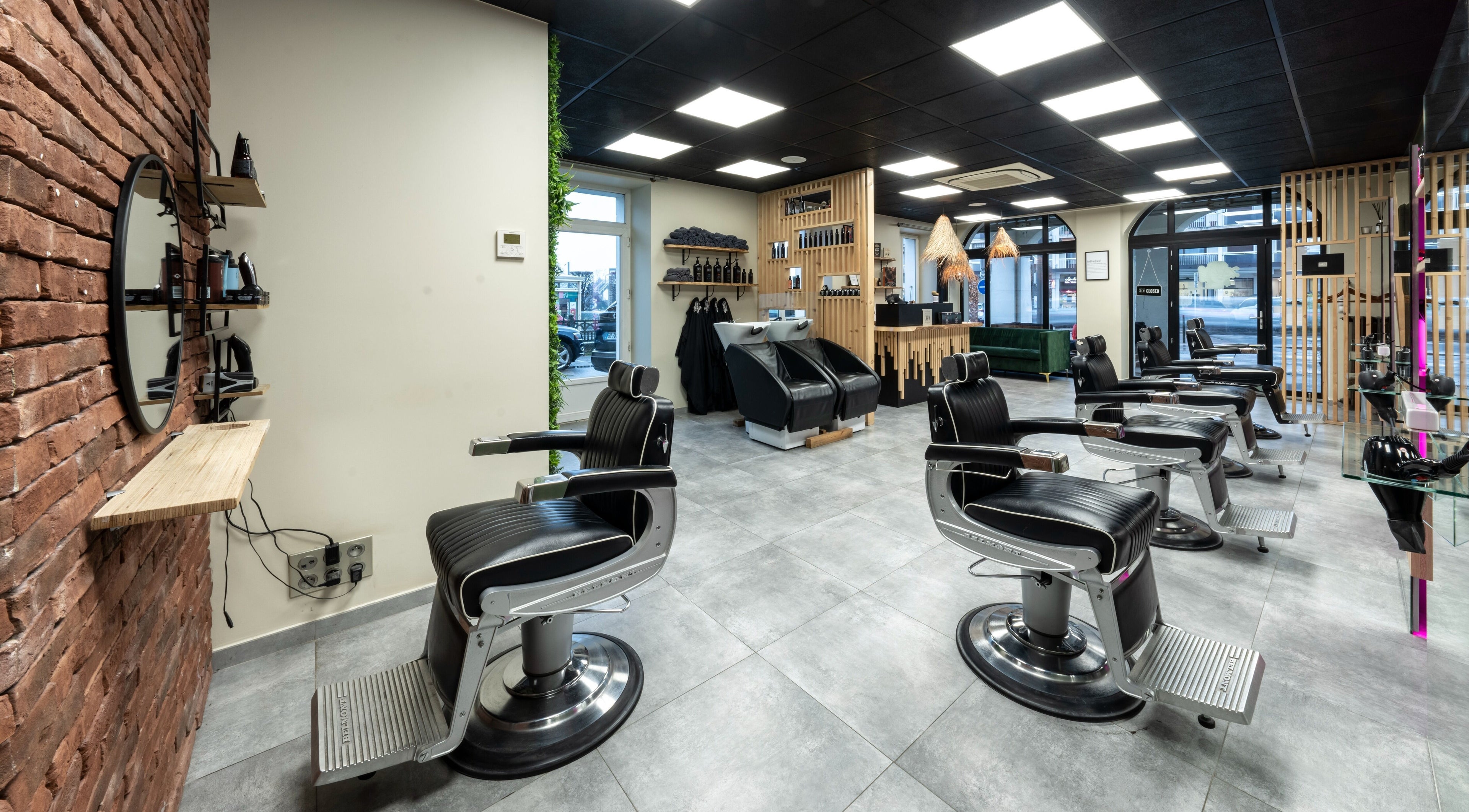 Intérieur moderne de L’atelier 65 à Saint-pierre-en-faucigny, avec fauteuils de barbier chic et décor raffiné.