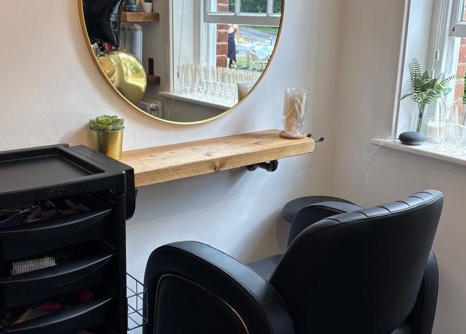 Stylish salon station at HairbyAmiEileen in Basingstoke, England, featuring a mirror, chair, and plants.