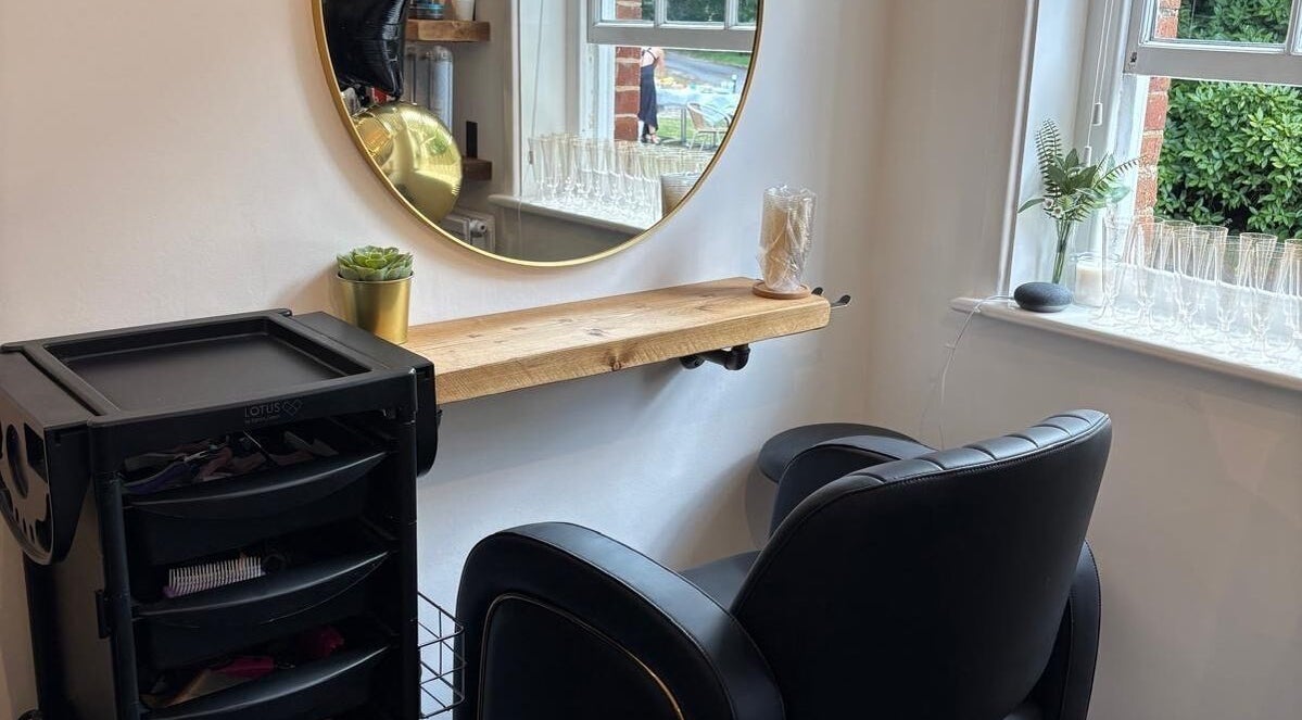 Stylish salon station at HairbyAmiEileen in Basingstoke, England, featuring a mirror, chair, and plants.