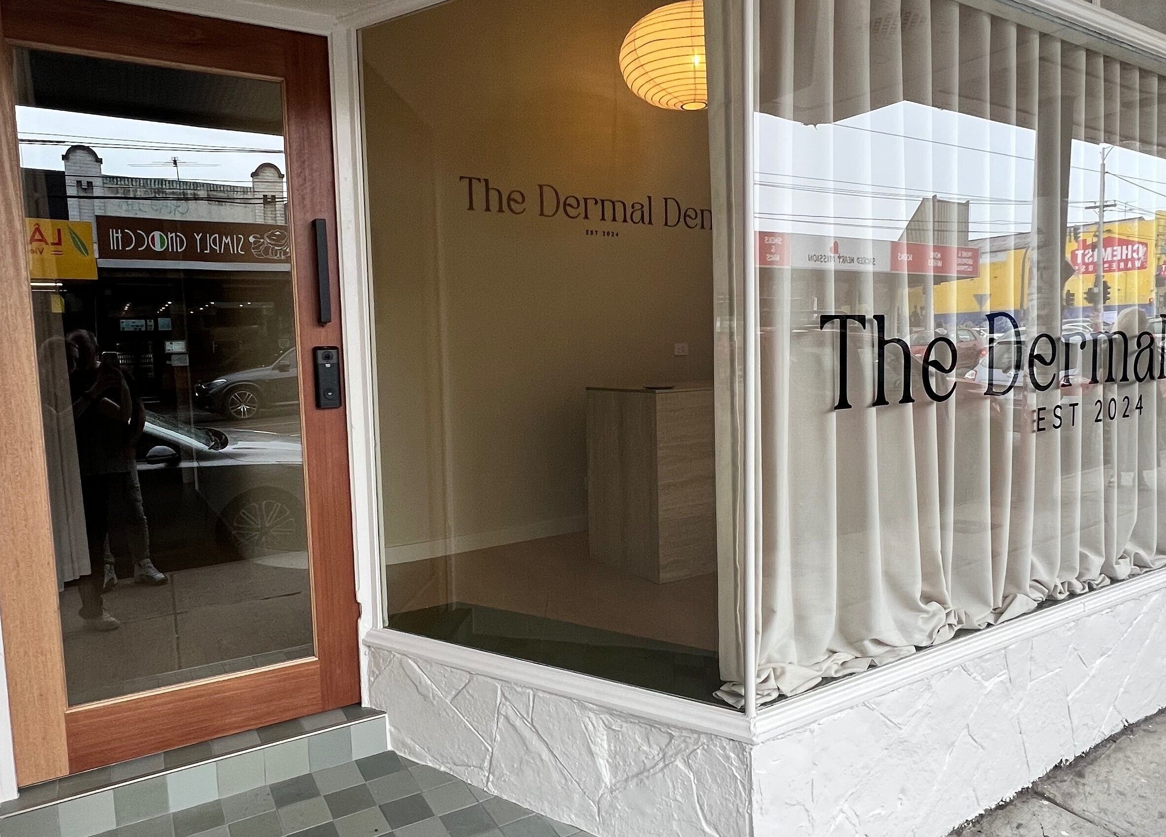 Entrance to The Dermal Den, Northcote, Victoria, AU with sleek wood door and elegant signage.