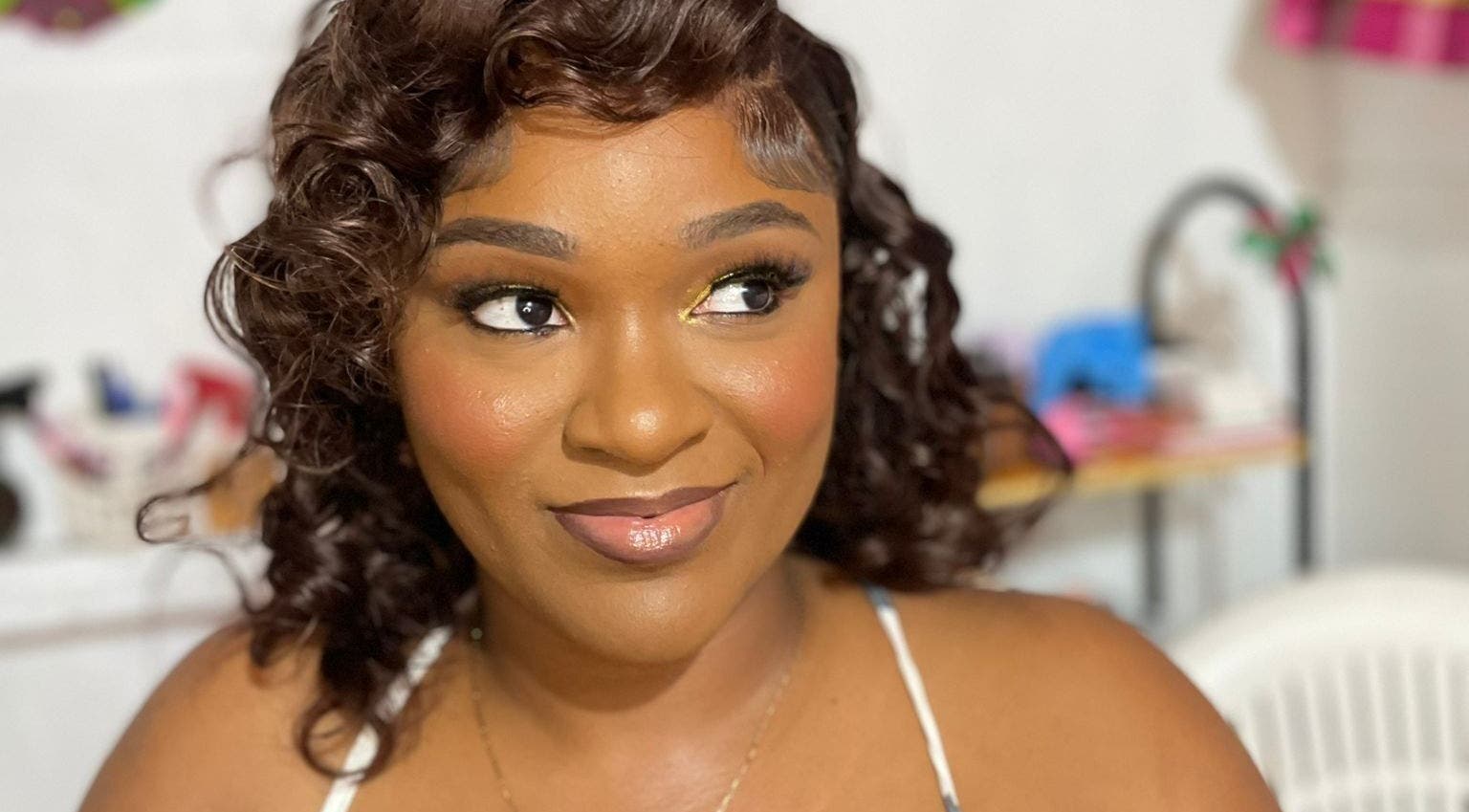 Smiling woman with elegant makeup at Jibeautyplus, Roseau, Saint George Parish, DM.