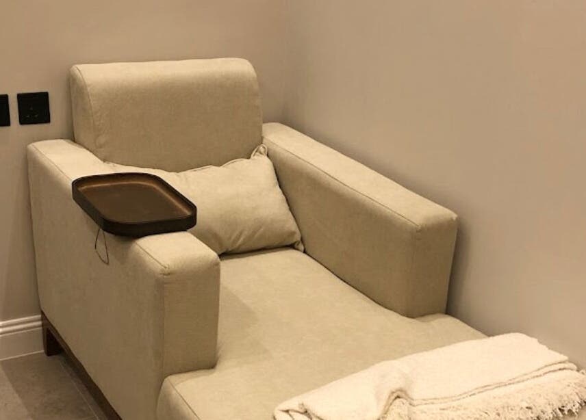 Comfortable beige chair in Four Sisters Salon, Shaqra, Riyadh Province, SA, with a cozy blanket for relaxation.