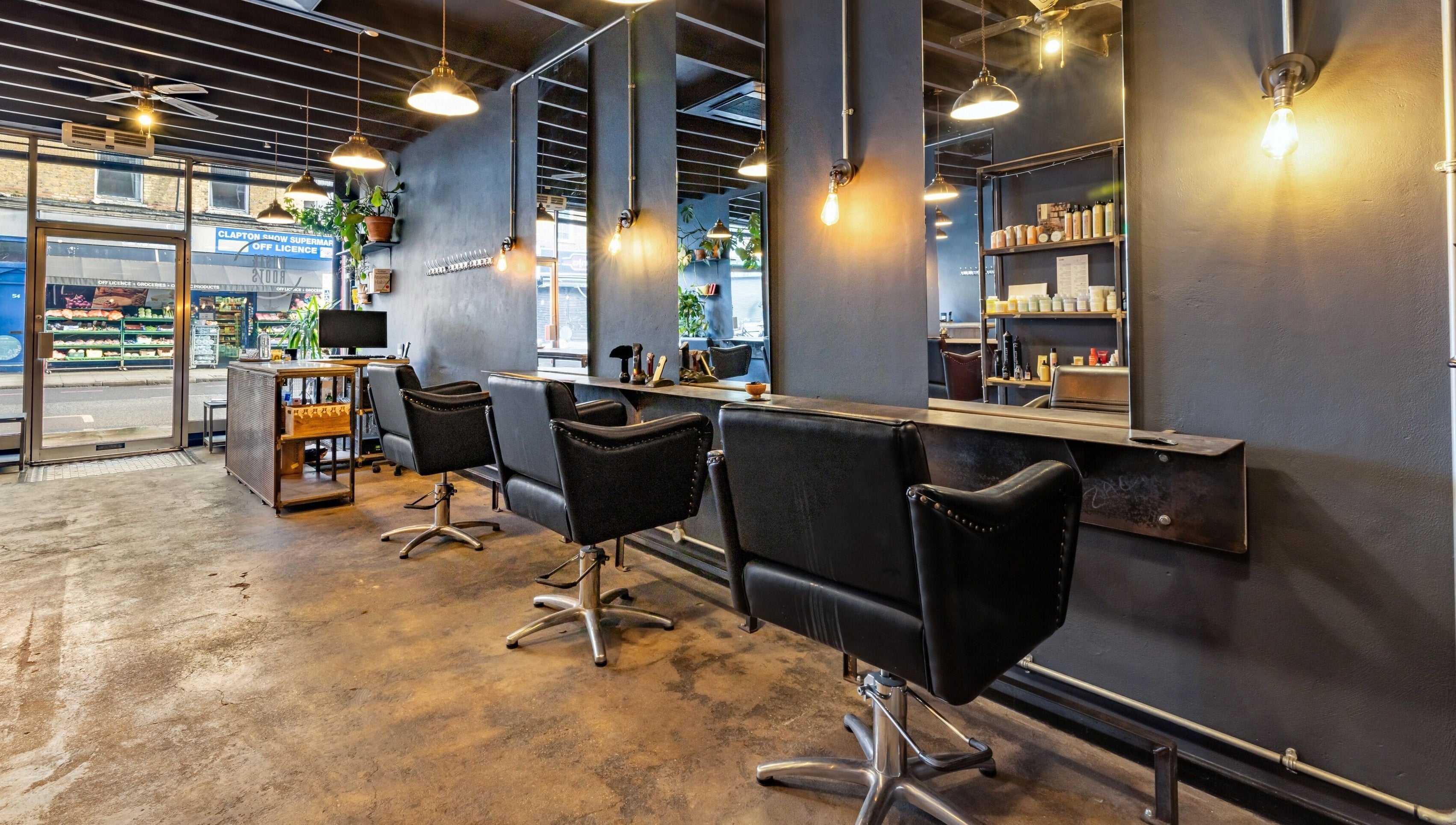 Modern salon interior at Rust & Roots, London, England, GB with stylish chairs and industrial decor.